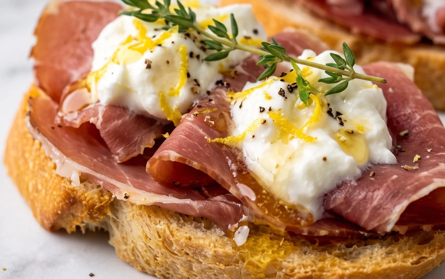 Beef Prosciutto Crostini with Burrata and Lemon Honey Drizzle